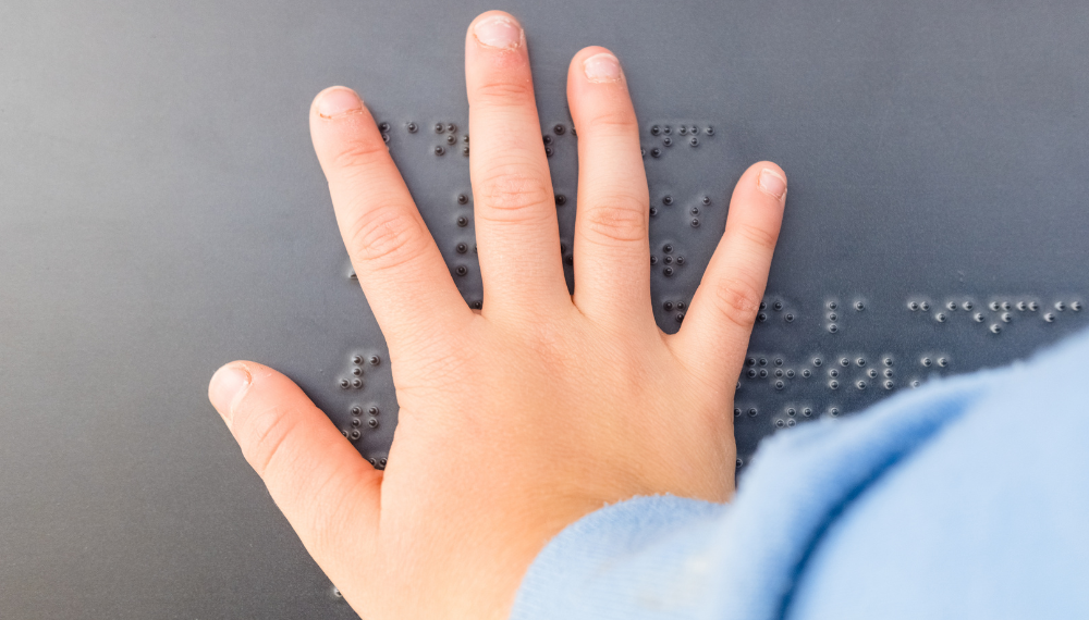 Un enfant malvoyant lit un texte en braille